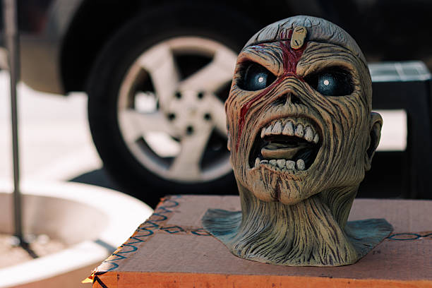 A very expressive latex rock band character mask with an open mouth, perfect for Halloween, with a sunny urban background.
