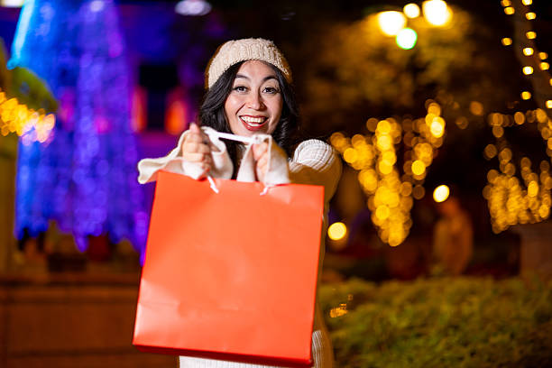 Happy woman doing Christmas shopping at night