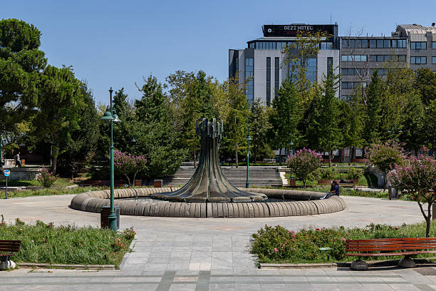 Istanbul, Turkey - August 16, 2025: View of the fountain in the center of Gezi Park, located near Taksim Square in the Beyoğlu district. The bronze fountain statue rises from the center of a circular pool surrounded by trees, benches, and walking paths. Gezi Park is one of the few green spaces in the heart of Istanbul and serves as a popular resting area for both locals and tourists.