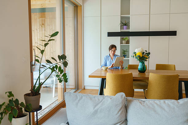 istock Hispanic Woman Using Digital Tablet in Modern Dining Room 2230375441