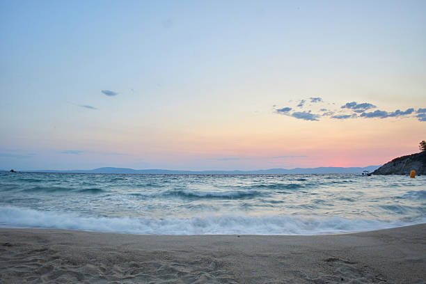 Sea water small waves splashing sand beach at sunset