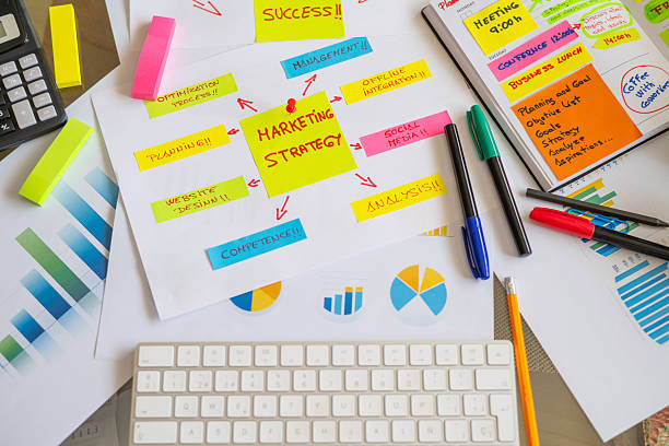 istock Desk covered with charts, graphs, colorful sticky notes, and markers, showcasing a vibrant marketing strategy planning session filled with creativity and innovation 2230382204