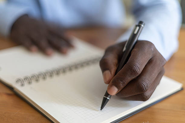 istock Close up of businessman writing in spiral notebook 2230387312
