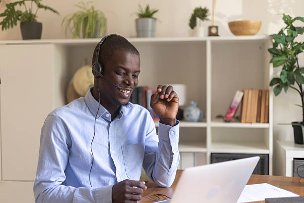 istock Young man working from his home office, using a headset and laptop for a video conference 2230387614