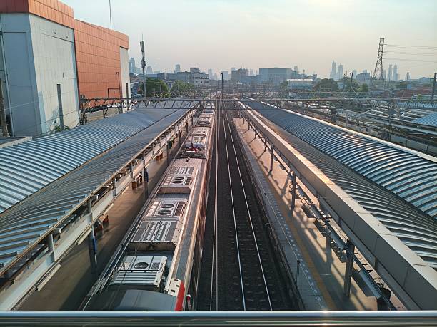 istock Overhead view of a train station with multiple tracks and platforms under covered structures. 2230392352