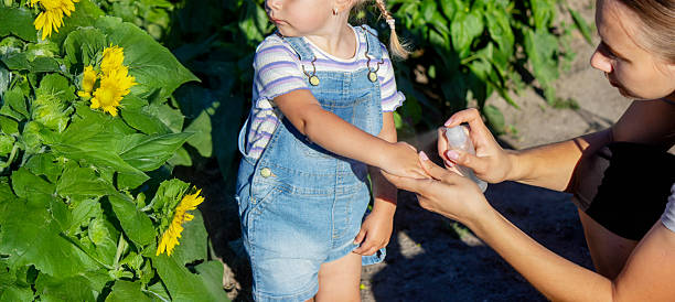 istock A mother sprays her child with mosquito repellent. 2230394956