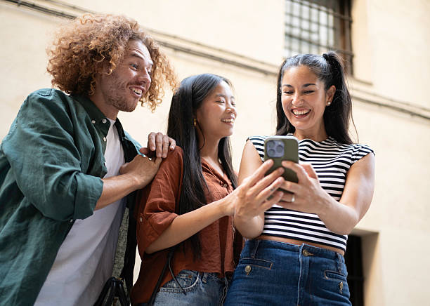 istock Three young adults watching something funny on a mobile phone 2230397830
