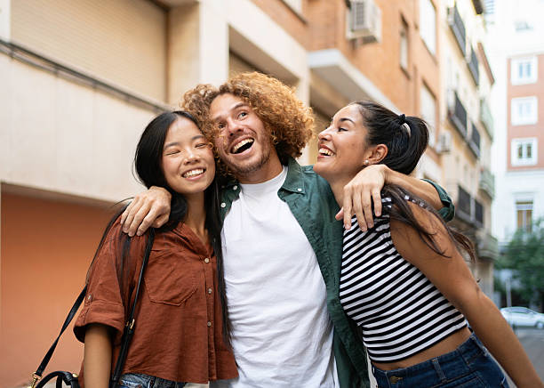 istock Three happy friends embracing in the city 2230398700