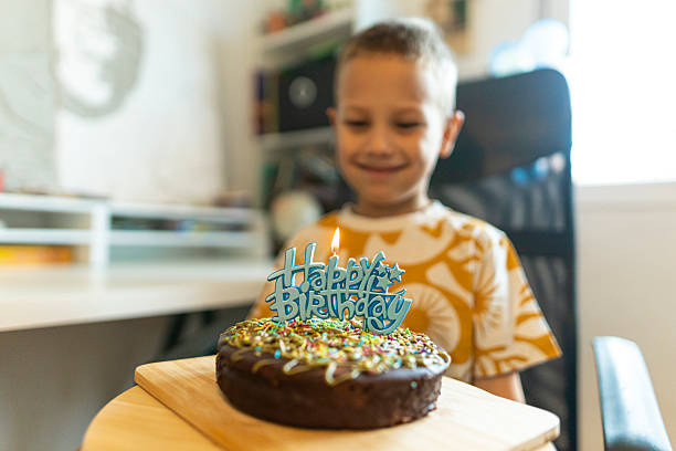 istock Boy proudly admiring his birthday cake. 2230398821