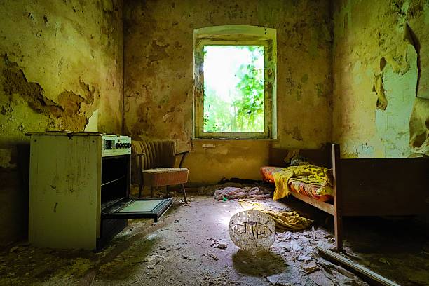 bed, stove and an old armchair inside a lost place