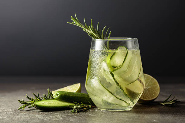 istock Hard seltzer with ice, rosemary, lime, and cucumber on a stone table. 2230404801