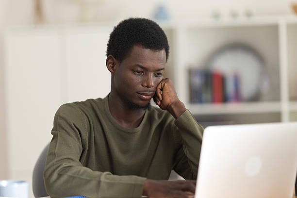 istock Young man concentrating while working from home on his laptop 2230406777