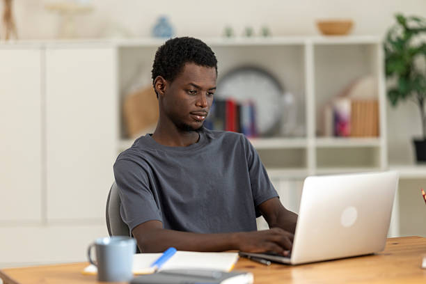 istock Young man concentrating on his work on a laptop in a home office setting 2230406806