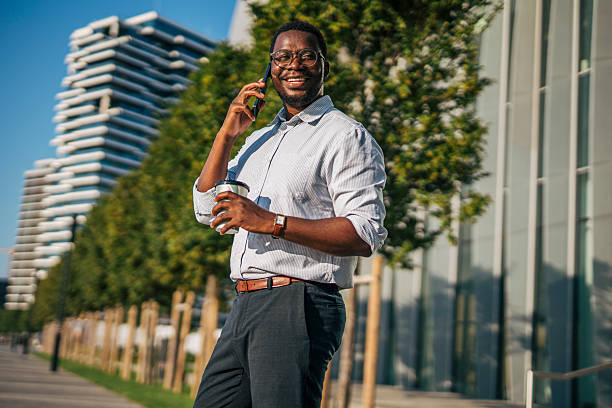 istock Smiling businessman walking and talking on phone, holding coffee 2230406978