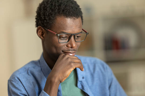istock Contemplative african professional wearing glasses, resting chin on hand while deep in thought 2230407049