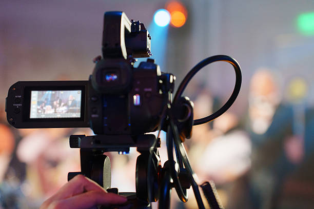 istock A professional videographer is filming a concert on stage. blurred stage. 2230407100