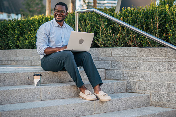 istock Businessman working remotely on laptop outdoors in urban setting 2230407296