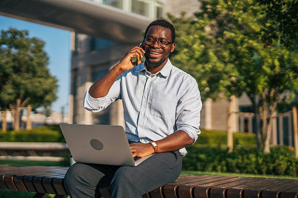 istock Young businessman working outdoors with laptop and smartphone 2230408283