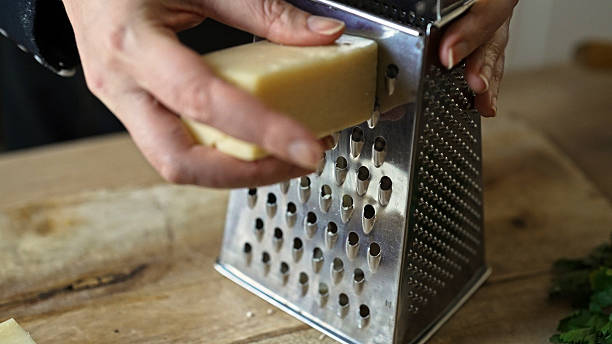 istock Grating hard cheese on metal kitchen grater. 2230413052