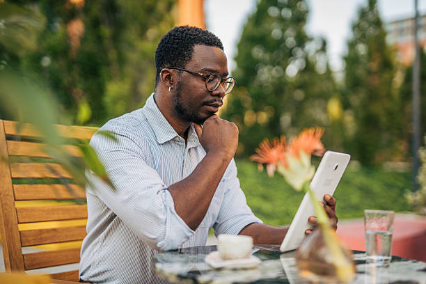 istock Pensive businessman using digital tablet at outdoor cafe 2230418453