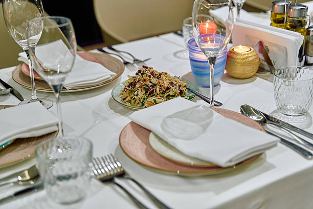 istock An Elegant Dining Table Setting with Gourmet Salad, Sparkling Glassware, and Soft Candlelight for an Inviting Culinary Experience 2230420642