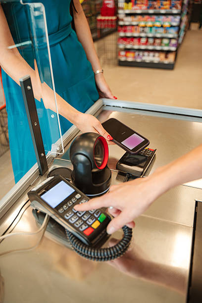 istock Customer paying with smartphone at supermarket checkout 2230421549