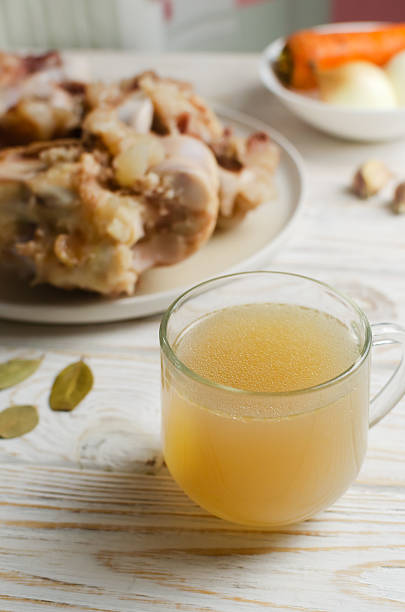 istock Veal bone broth in a glass cup with ingredients on a white table. Collagen concept. Selective focus. Vertical orientation. Copy space 2230422830