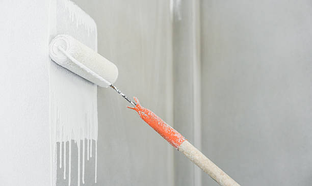 istock Rolling paintbrush paint white color on clean cement wall room interior background, Roller tool renovation decor construction building house professional painter 2230423960