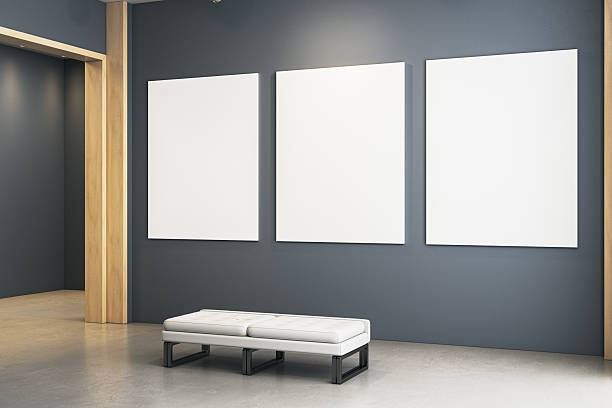 istock Contemporary gallery interior with three large blank vertical canvases on dark wall and white bench in minimalist exhibition room setup. 3D Rendering 2230432261