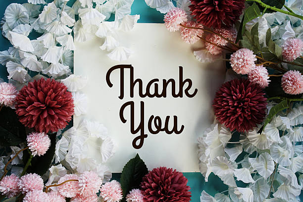 istock Thank You text with flowers frame decoration top view on blue background 2230436229