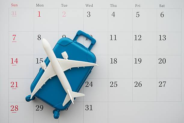 istock Airplane and suitcase on white calendar background. 2230437462
