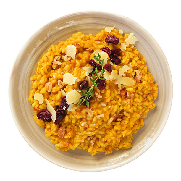 Pumpkin risotto with cranberries and parmesan cheese. Top down view isolated on a white background. Autumn meal.