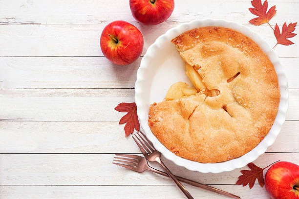 Photograph of an apple pie on a wooden table in close-up with copy space. Studio photography.