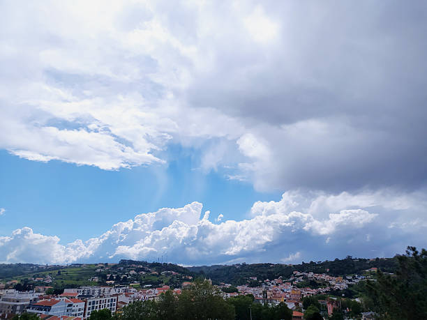istock Dramatic sky over a hillside town, contrasting blue and grey clouds. Evokes tranquility and impending weather. Perfect for travel, nature or serenity. 2230449441