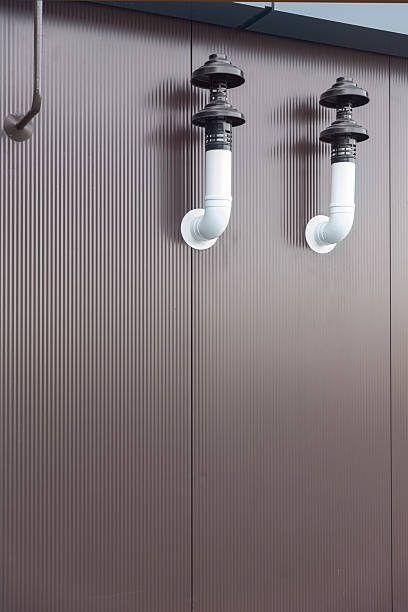 Two exhaust pipes are protruding from a corrugated metal wall