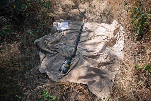 Hunting equipment lying on a canvas in the woods during a hunting trip