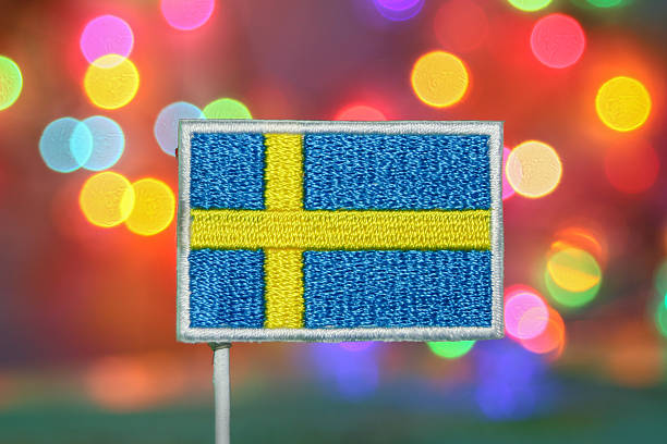 istock Embroidered Sweden flag with sparkling rainbow bokeh, symbolizing joy, unity, and national holiday spirit. 2230455834