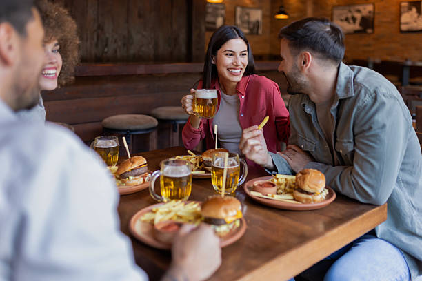 istock People Enjoying Cozy Pub Atmosphere with Food and Drinks 2230468902