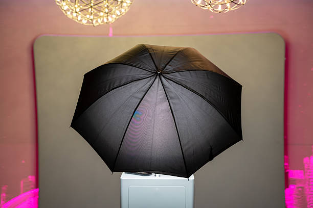 Photo booth setup with black umbrella light and backdrop.
