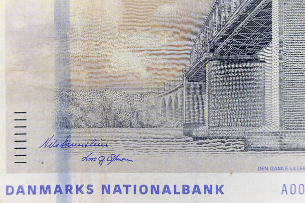 Close-up of a Danish banknote featuring an engraving of a bridge and landscape. Predominant colors are pale yellow, blue, and gray.