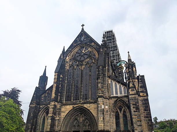 Glasgow, Scotland - July 14 2025: The medieval Gothic facade of the historic Glasgow Cathedral, also known as St Mungo's Cathedral, with its tower covered in scaffolding for restoration work