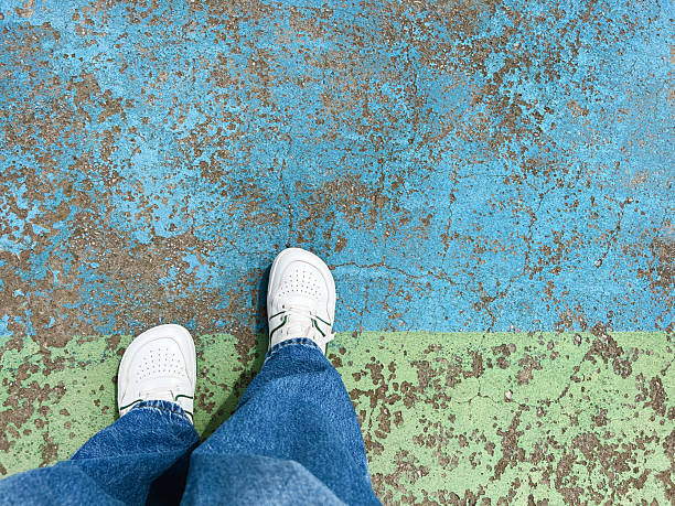 White shoes with jeans on blue urban grunge background of asphalt