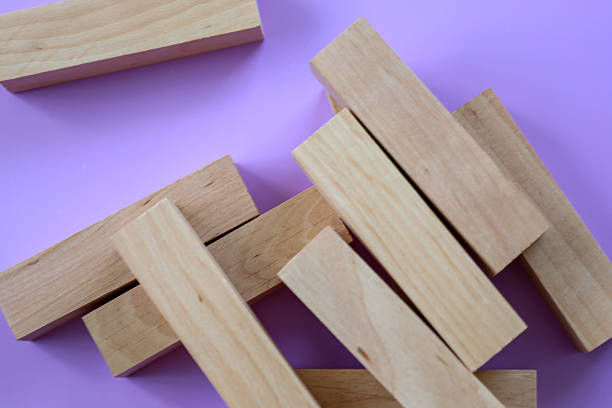 istock Wooden blocks are scattered randomly on a vibrant lilac background, creating an interesting composition. The natural texture of the light wood contrasts with the rich, solid color, giving the shot a minimalist and modern look. 2230477273
