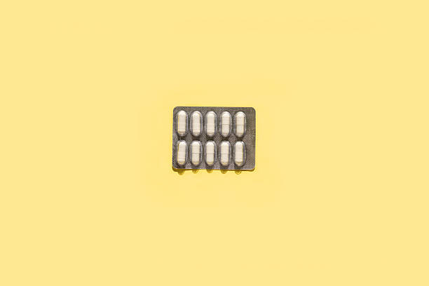 istock Blister with white capsules on a butter yellow background 2230480013