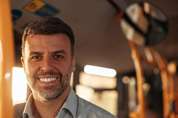 A man on the train looks thoughtfully through the window, his gaze meeting the passing scenery, a silent observer to the world in motion outside