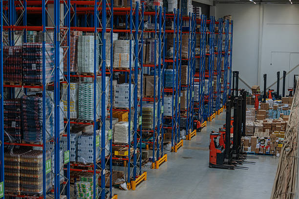 istock Large warehouse with tall blue racks and forklifts 2230483750