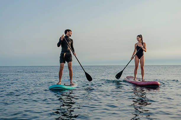 istock Man and a woman paddleboarding on a calm sea 2230483784