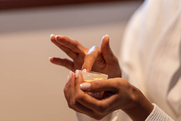 istock Close-up of woman scooping face cream 2230485241