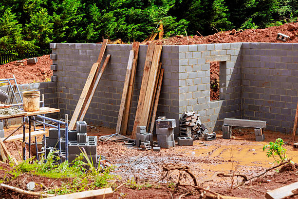 istock Construction site in progress with concrete blocks and wooden planks surrounded by trees on works day 2230485701