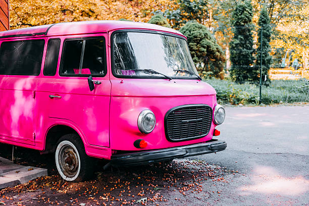 istock Vintage pink van parked under trees in a serene outdoor setting during sunny weather 2230488077